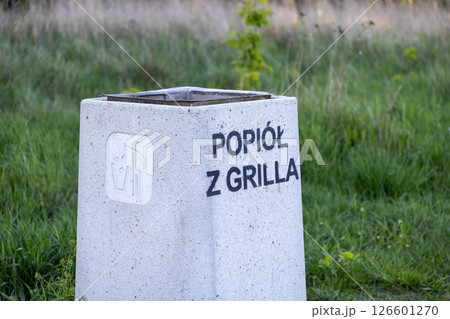 Outdoor public concrete ash bin with text Ash from grill and icon offers designated safe disposal point for hot ash in urban environment Outdoor public concrete ash bin with text Ash from grill and icon offers designated safe disposal point for hot ash in urban environment 126601270