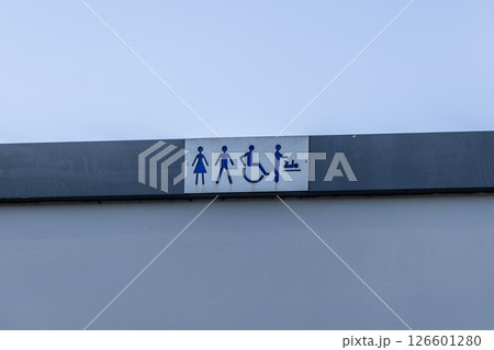 Public restroom sign with female male disabled and baby change icons on building facade indicating available facilities 126601280