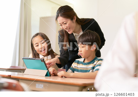 タブレットを使う小学生と指導する先生 126601403