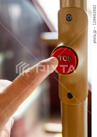 a Passenger Finger Pressing the Stop Button on a Red London Bus, Capturing a Moment in the Public Transport Experience. 126602682