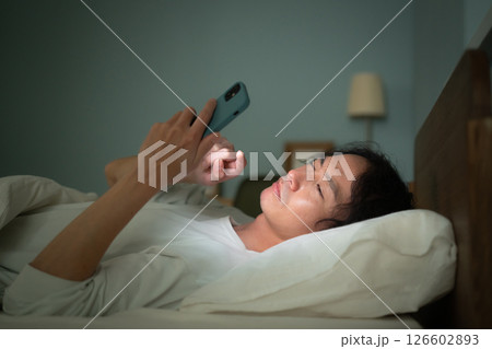 男性　スマートフォン　スマホ　ベッド 126602893