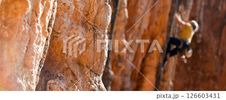 A man is climbing on the rocks in the mountains. 126603431