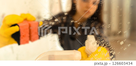 Young woman is washing mirror in the bathrom. 126603434