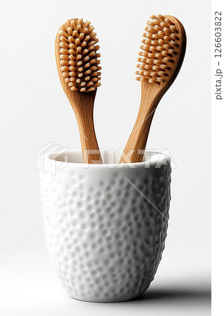 Two wooden brushes in a white ceramic cup on a white background. Eco-friendly products. Sustainable cleaning product. Two wooden brushes in a white ceramic cup on a white background. Eco-friendly products. Sustainable cleaning product. 126603822