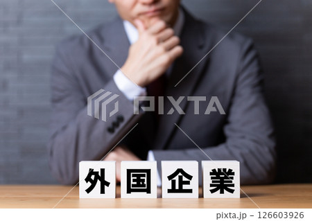 外国企業のブロックとスーツを着て悩むミドル男性ビジネスマン 外国企業のブロックとスーツを着て悩むミドル男性ビジネスマン 126603926