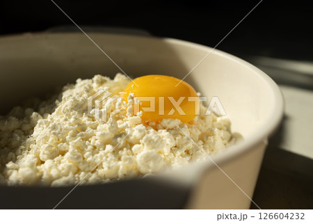 A Fresh Egg Yolk Served Generously on Top of Creamy Cottage Cheese for a Delicious Meal A Fresh Egg Yolk Served Generously on Top of Creamy Cottage Cheese for a Delicious Meal 126604232
