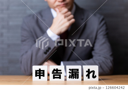 税務調査のブロックとスーツを着て悩むミドル男性ビジネスマン 税務調査のブロックとスーツを着て悩むミドル男性ビジネスマン 126604242