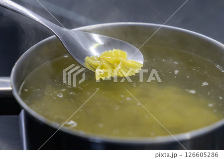 boiled farfalle pasta lifted from steaming pot with silver spoon over hot water boiled farfalle pasta lifted from steaming pot with silver spoon over hot water 126605286