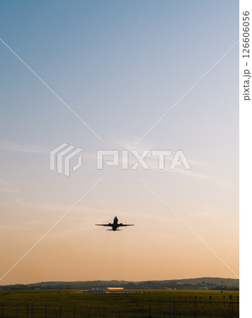 Jet plane taking off from airport runway during golden hour, with clear sky and peaceful landscape in background, creating a scenic view of air travel and aviation industry. commercial aviation travel Jet plane taking off from airport runway during golden hour, with clear sky and peaceful landscape in background, creating a scenic view of air travel and aviation industry. commercial aviation travel 126606056