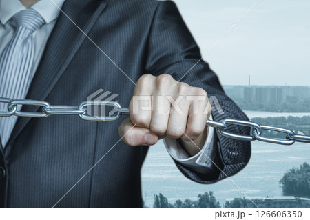 A man holding chains symbolises a business connection. A man holding chains symbolises a business connection. 126606350