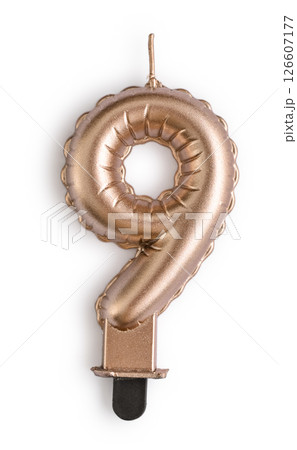 Golden cake candle in shape of number nine Golden cake candle in shape of number nine 126607177