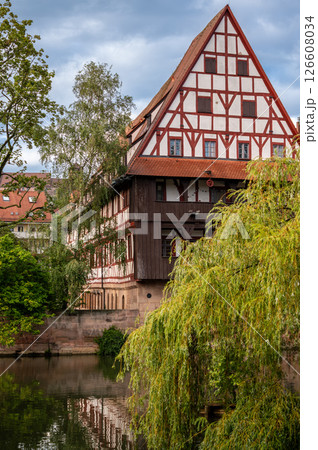 Nuremberg, Germany, August 2, 2023. Beautiful shot with an iconic image of the fairytale atmosphere of the place. On the beautiful summer day the half-timbered house is reflected in the water. Nuremberg, Germany, August 2, 2023. Beautiful shot with an iconic image of the fairytale atmosphere of the place. On the beautiful summer day the half-timbered house is reflected in the water. 126608034
