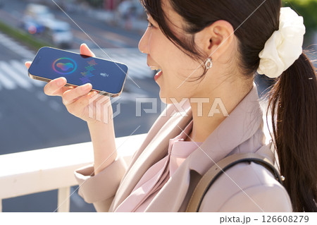 屋外で音声アシスタントと会話する女性 屋外で音声アシスタントと会話する女性 126608279