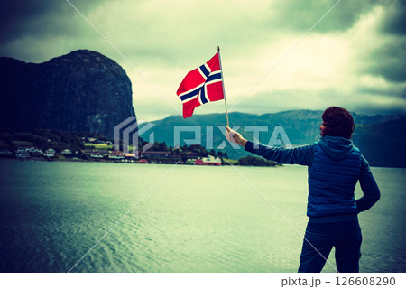Tourist with norwegian flag on fjord Tourist with norwegian flag on fjord 126608290