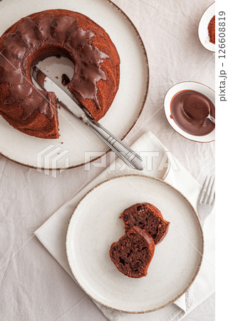 Chocolate cake with chocolate icing on white wooden table. Top view Chocolate cake with chocolate icing on white wooden table. Top view 126608819