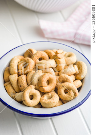 Salted crispy snack rings in bowl on kitchen table. 126609881