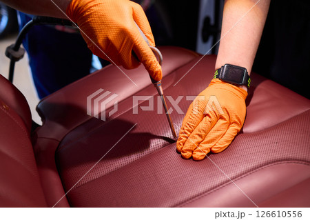 Cleaning a Luxury Car Seat with a Detail Brush and Foam for Maintaining Its Appearance Cleaning a Luxury Car Seat with a Detail Brush and Foam for Maintaining Its Appearance 126610556