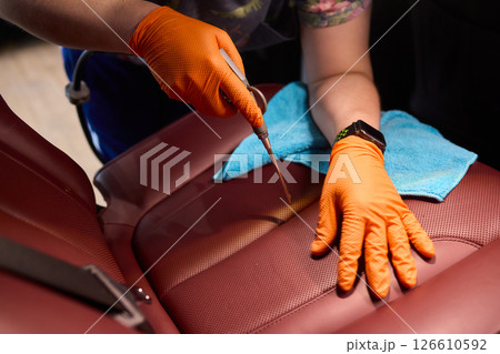 Cleaning a Luxury Car Seat with a Detail Brush and Foam for Maintaining Its Appearance Cleaning a Luxury Car Seat with a Detail Brush and Foam for Maintaining Its Appearance 126610592
