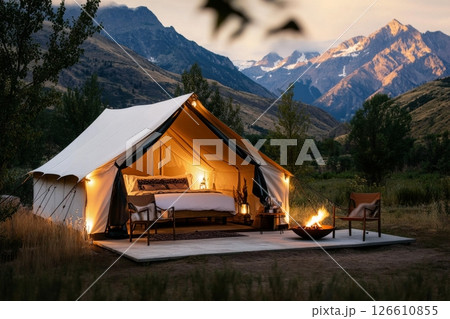 Cozy Glamping Setup With Mountain Views at Dusk, Featuring a Tent, Fireplace, and Stylish Seating 126610855