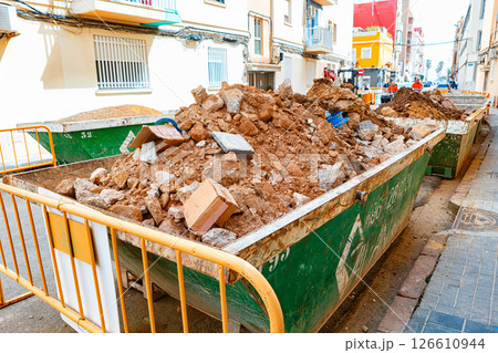 Spain, Valencia, March 29, 2024: Construction Site With Debris Containers Filled With Dirt and Rubble on a Busy Urban Street Spain, Valencia, March 29, 2024: Construction Site With Debris Containers Filled With Dirt and Rubble on a Busy Urban Street 126610944