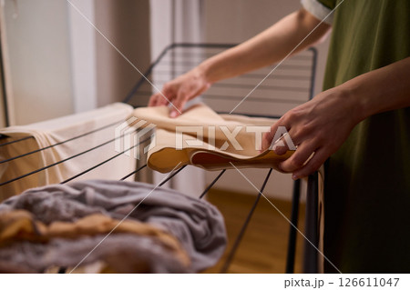 Arranging Freshly Laundered Towels Neatly on a Drying Rack for Optimal Drying and Organization 126611047