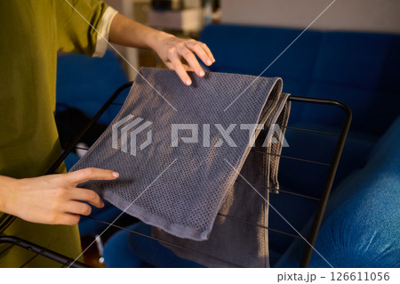 Arranging Freshly Laundered Towels Neatly on a Drying Rack for Optimal Drying and Organization 126611056