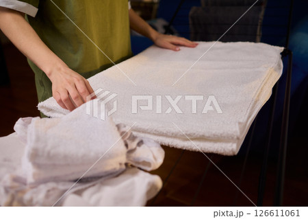 Arranging Freshly Laundered Towels Neatly on a Drying Rack for Optimal Drying and Organization 126611061