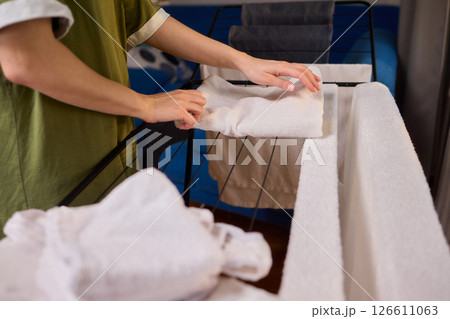 Arranging Freshly Laundered Towels Neatly on a Drying Rack for Optimal Drying and Organization 126611063