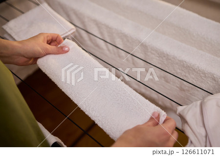 Arranging Freshly Laundered Towels Neatly on a Drying Rack for Optimal Drying and Organization 126611071
