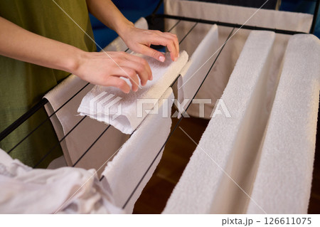 Arranging Freshly Laundered Towels Neatly on a Drying Rack for Optimal Drying and Organization Arranging Freshly Laundered Towels Neatly on a Drying Rack for Optimal Drying and Organization 126611075
