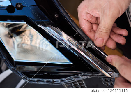 Careful precision is essential when installing a car headlight assembly for optimal performance Careful precision is essential when installing a car headlight assembly for optimal performance 126611113
