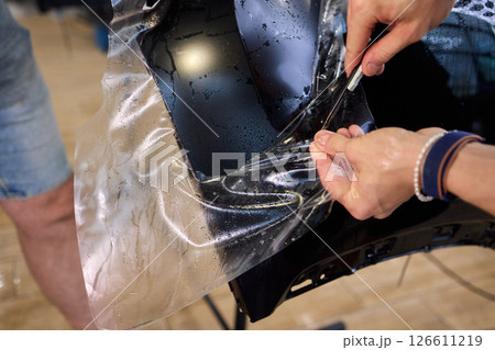 Applying a Protective Film on the Surface of Your Car for Enhanced Durability and Shine 126611219