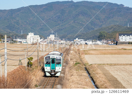 【牟岐線】田畑の真ん中を駆け抜ける普通列車 126611469