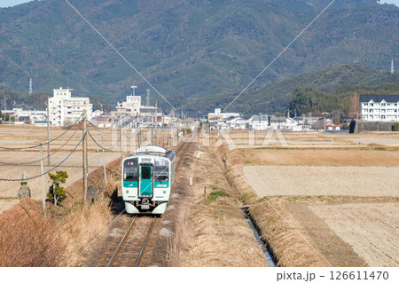 【牟岐線】田畑の真ん中を駆け抜ける普通列車 126611470