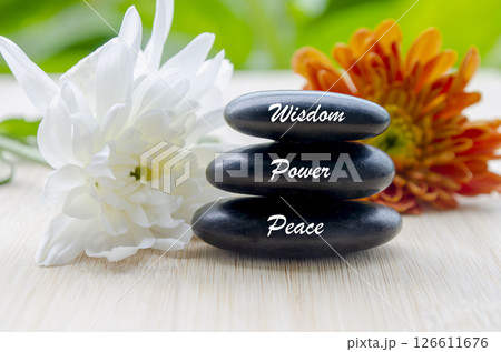Wisdom, Power and Peace text on zen stones with blooming flowers Wisdom, Power and Peace text on zen stones with blooming flowers 126611676