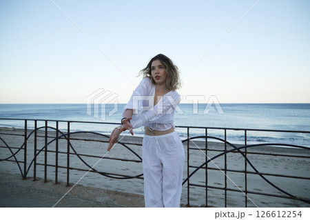 Girl Dances In White Clothes Outside On The Street Near The Ocean Girl Dances In White Clothes Outside On The Street Near The Ocean 126612254