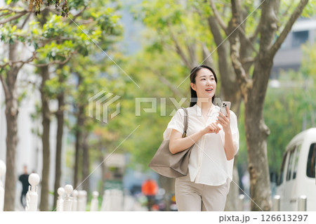 街中でスマホを持って歩く女性 126613297