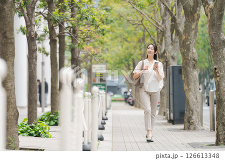 街中でスマホを持って歩く女性 126613348