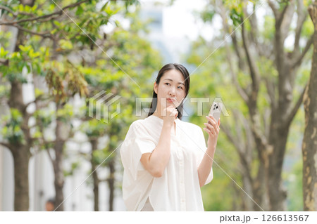 街中でスマホを持って歩く女性 126613567