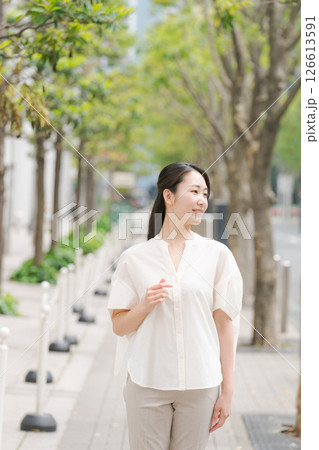 街中に立って微笑む女性 126613591