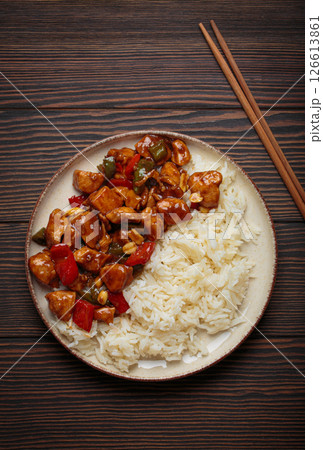 Kung pao chicken with peanuts and rice on a plate top view, traditional Chinese cuisine Kung pao chicken with peanuts and rice on a plate top view, traditional Chinese cuisine 126613861