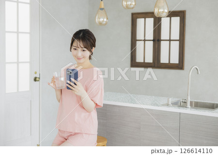 キッチンでスマホを見る女性 126614110