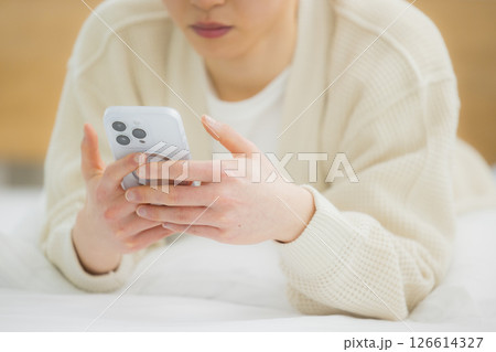 ベッドでスマホを使う若い男性 ベッドでスマホを使う若い男性 126614327