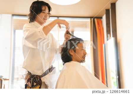ヘアカットをする男性スタイリストと高齢男性客 126614661