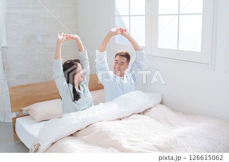 起床して伸びをするシニア夫婦 126615062