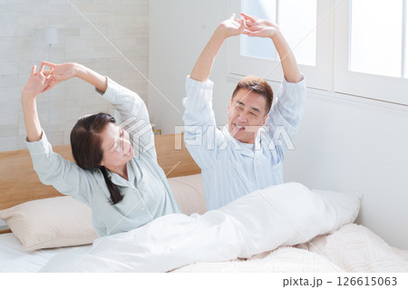 起床して伸びをするシニア夫婦 起床して伸びをするシニア夫婦 126615063