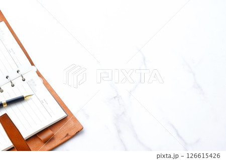 リング式のシステム手帳を開いてデスクワークをしているイメージ 126615426