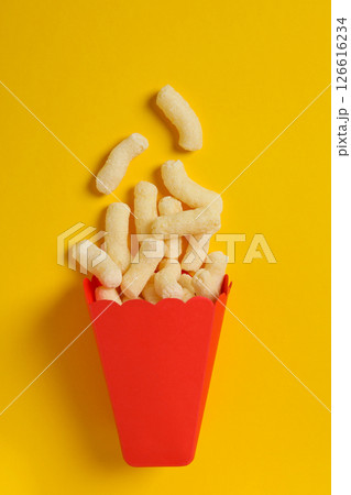 Corn sticks in red paper bag on yellow background, top view 126616234
