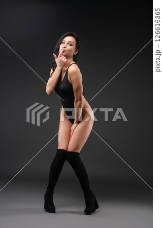 Graceful ballet dancer in striking pose against dark background Graceful ballet dancer in striking pose against dark background 126616865