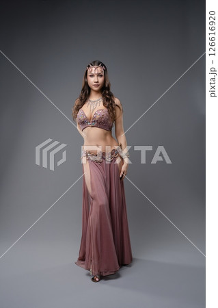 Elegant dancer showcasing traditional attire in a studio setting 126616920